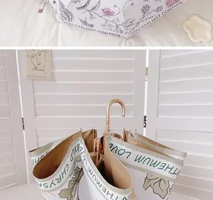 Détail d'un parasol rétro français avec des motifs floraux élégants et une poignée dorée chic