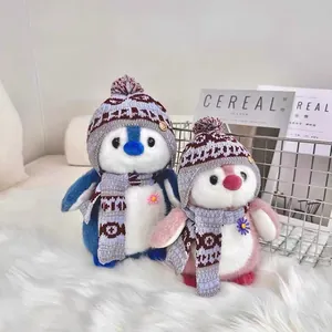 Pair of cute penguin plush toys with winter hats and scarves on white fur.