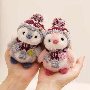 Pair of adorable plush penguin toys featuring cozy knitted hats and patterned scarves