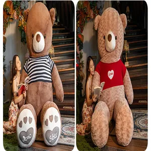 Oversized brown teddy bear plush toy with striped sweater and heart embroidery