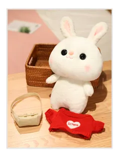 Detailed view of white plush rabbit doll with red heart sweater and beige bag