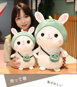Detailed close-up of two cute white plush rabbits in dinosaur hoods held by an Asian model