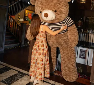 Giant brown plush teddy bear with a striped sweater shown in a warm lifestyle hug