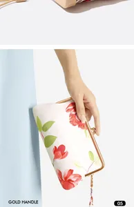 Detail eines Mini-Taschenschirms in einer geblümten Hülle, wie eine Clutch gehalten