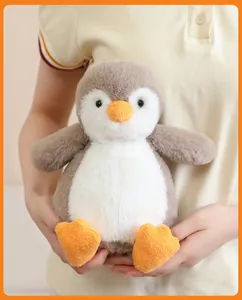 Close-up of a soft gray penguin plush toy being held, showing its fluffy texture.