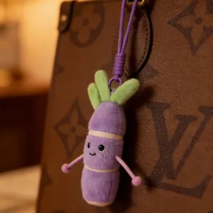 Primer plano de un lindo llavero de peluche de caña de azúcar morada en un bolso marrón