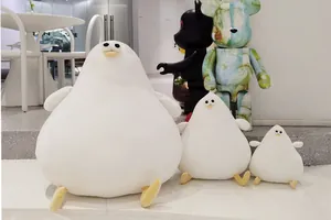 Set of three cute white Danish seagull plush toys in a stylish minimalist cafe scene.