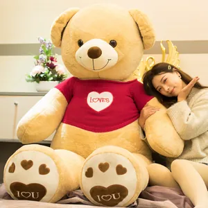 Close-up of a giant teddy bear in a red sweater featuring a 'LOVES' heart patch.