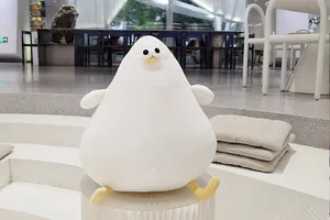 Soft white plush seagull bird toy with a cute pear-shaped body in a modern cafe