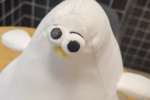 Close-up detail of a cute white plush seagull with bulging eyes and yellow beak