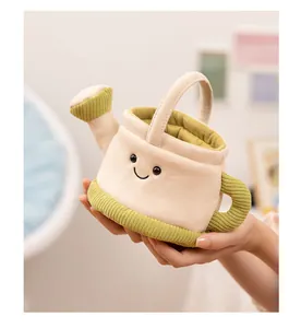 Close-up of a soft plush watering can toy with a smiling face held in hands