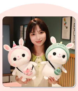 Cute rabbit plush toys in unicorn and dinosaur costumes held by model in home setting