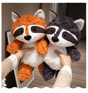 Close-up detail of soft orange and grey forest animal raccoon plush toys in hands