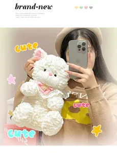 Close-up of a cute white plush kitten toy with pink bow and lace collar decoration.