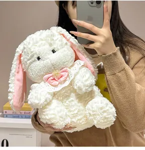 Close-up of a cute plush white rabbit toy with a pink bow held by a model in mirror