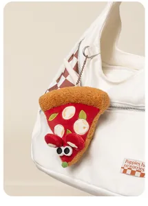 Vista detallada de un lindo colgante de peluche con forma de ratón pizza en un bolso de lona