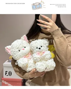 Detailed shot of two cute white plush animal toys featuring pink bows and lace bibs