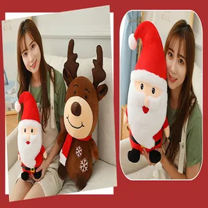 Close-up of a model holding soft Santa Claus and Reindeer plush toys for Christmas.