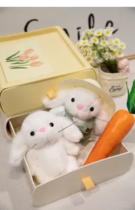 Detail of white plush gardener bunnies in a cream organizer with a carrot
