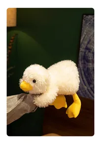 Detailed close-up of a white fluffy duck plush toy with a yellow beak and feet.