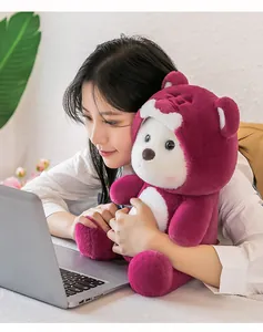 Cozy detail of a woman holding a soft purple teddy bear plush toy near a laptop.