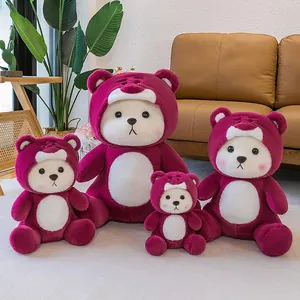 Set of four magenta strawberry teddy bear plush toys in various sizes on a rug