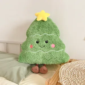Vue détaillée d'un coussin en peluche en forme de sapin de Noël vert souriant avec une étoile.