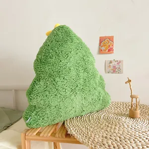Coussin sapin de Noël en peluche verte présenté dans un décor intérieur chaleureux