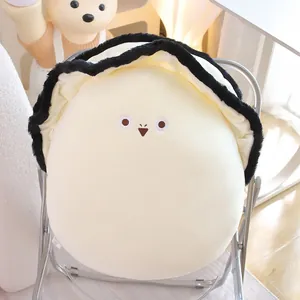 Coussin en peluche huître créatif avec un visage brodé mignon sur une chaise.