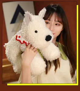 Close-up of a soft white West Highland Terrier plush toy held by a model