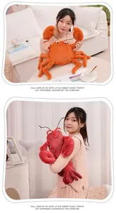 Juguetes de peluche realistas de langosta y cangrejo sostenidos por una modelo.