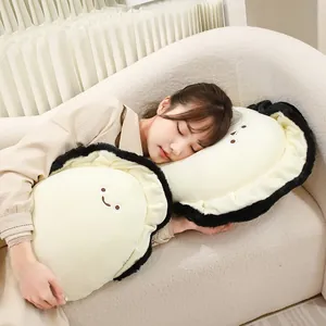 Coussins en peluche créatifs en forme d'huître et d'ormeau sur un canapé crème avec modèle