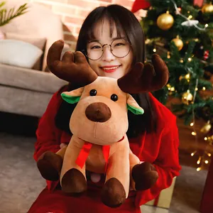 Morbido peluche di renna di Natale marrone tenuto da una modella in un set festivo