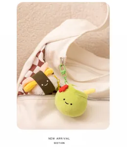 Detailopname van schattige pluche kokosnoot- en sushi-hangers aan een witte canvas tas