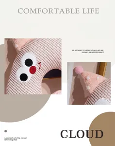 Detailed view of soft plush pink checkered cartoon eye neck pillow for travel and naps