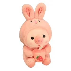 Lindo peluche de cerdo con disfraz de conejo rosa y té de fresa