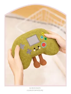 Close-up of a cute green retro game controller plush toy with legs held in hands