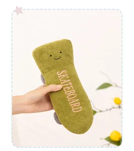 Close-up of cute green skateboard plush toy with embroidered smile face