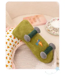 Close-up view of a green plush skateboard toy with embroidered BOOM text and soft texture