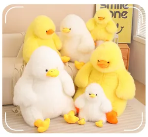 Collection of cute fuzzy long-hair duck plush toys in yellow and white on a sofa