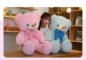 Große Plüsch-Teddybären in Rosa und Blau mit Schleifen, präsentiert von einem Modell.