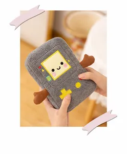 A detailed view of a cute gray retro game console plush toy being held gently in hands