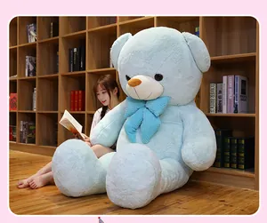 Großer hellblauer Teddybär als Plüschtier in einer gemütlichen, warmen Leseecke.