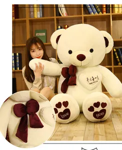 Large white plush teddy bear with burgundy bow and heart embroidery detail close-up view