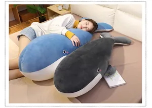 Detail showing the soft texture and scale of the whale plush body pillow in a bedroom