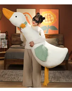 Giant soft white goose plush body pillow held by a woman in a cozy bedroom interior