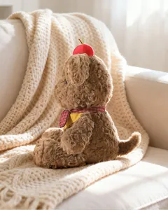 Detailed side view of a cute plush dog with an apple hat on a soft white knitted blanket