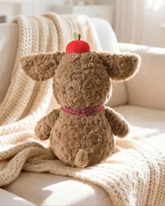 Back view showing the soft curly fur texture of a plush puppy wearing an apple hat
