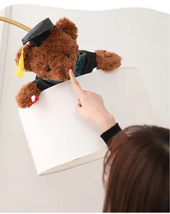 Primer plano de un oso de peluche de graduación marrón con un birrete negro de gala.
