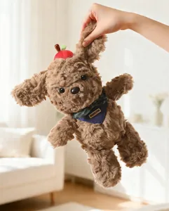 Close-up of cute brown teddy dog plush toy with a red apple hat and blue bandana